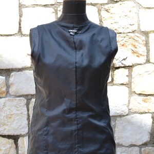 May include: Black sleeveless jacket with a zipper closure and a DKNY label on the back.