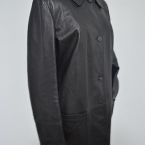 May include: A black leather coat with a collar and button closure. The coat has a long, straight silhouette and two pockets.