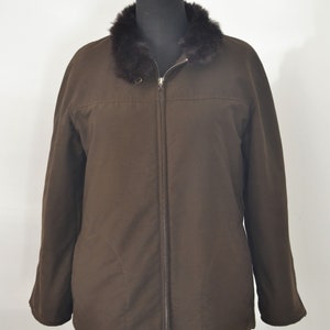 K&ouml;nnte beinhalten: Eine braune Rei&szlig;verschlussjacke mit einem Kunstfellkragen. Die Jacke hat einen Rei&szlig;verschluss und ein gestepptes Futter.