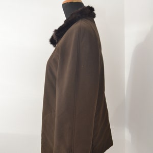 K&ouml;nnte beinhalten: Eine braune Jacke mit einem Pelzkragen. Die Jacke hat einen Rei&szlig;verschluss an der Seite.