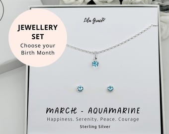 May include: A silver necklace and earrings set with a light blue aquamarine gemstone. The jewelry is in a white box with the text "JEWELLERY SET Choose your Birth Month MARCH - AQUAMARINE Happiness. Serenity. Peace. Courage Sterling Silver".