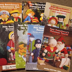 May include: A collection of eight knitting pattern books featuring various knitted dolls and characters. The books are titled "Jean Greenhowe's MacScarecrow Clan", "Jean Greenhowe's Scarecrow Family", "Jean Greenhowe's Christmas Treasures", "Jean Greenhowe's Bazaar", "Jean Greenhowe's Tay Collection", "Jean Greenhowe's Mascot", and "Jean Greenhowe's Christmas Special".