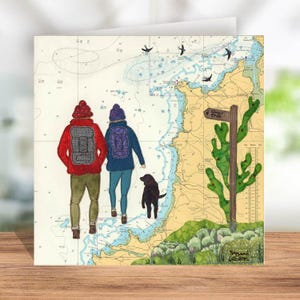 May include: A greeting card featuring a watercolour illustration of two people with backpacks and a dog walking on a map with a sign that says "Coast Path".