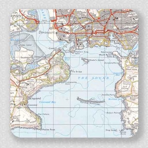 May include: Square coaster with a detailed map of a coastal region, showing blue sea, beige land, and red and black road markings. Place names include Devonport and The Sound.