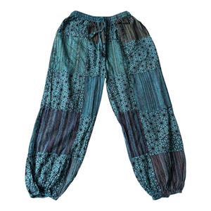 Könnte beinhalten: Weit geschnittene Hose mit Patchwork-Design in Blaugrün-, Blau- und Dunkelgrautönen. Der Stoff wechselt zwischen Bahnen mit einem schwarzen geometrischen Sternmuster und Bahnen mit vertikalen Streifen. Mit elastischem Kordelzug in der Taille.