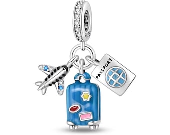 May include: Silver charm with a blue suitcase, airplane, and passport with a globe. The suitcase has colorful stickers and wheels. The charm has clear crystals.