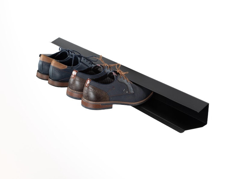Peut inclure: Un porte-chaussures en m&eacute;tal noir avec trois paires de chaussures en cuir bleu fonc&eacute; avec des accents marrons.