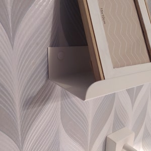May include: White shelf with a white picture frame on top. The frame is labeled "15x10cm".