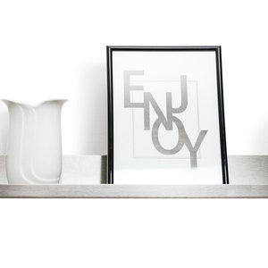 May include: A stainless steel shelf with a white vase, a framed print with the word "ENJOY" in silver lettering, and a gray candle.