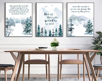 Puede incluir: Tres impresiones enmarcadas en acuarela con escenas de montañas y bosques. Cada impresión tiene una cita inspiradora diferente en texto negro. La paleta de colores incluye tonos de azul, verde y blanco, creando una estética serena y natural.