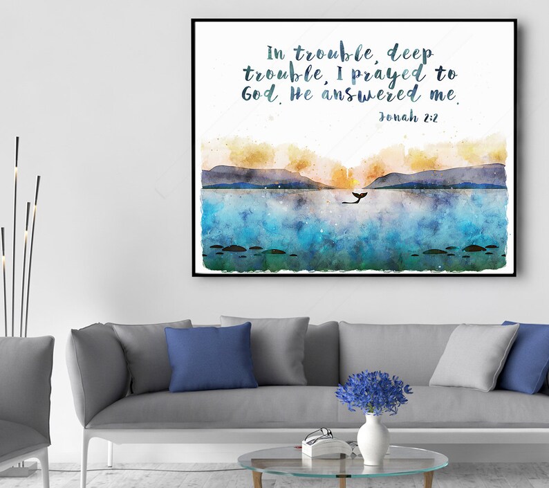 May include: Watercolor art print in a black frame. The artwork depicts a seascape with mountains, a whale, and the text "in trouble, deep trouble, I prayed to God. He answered me. Jonah 2:2." The color palette includes blues, yellows, and greens.