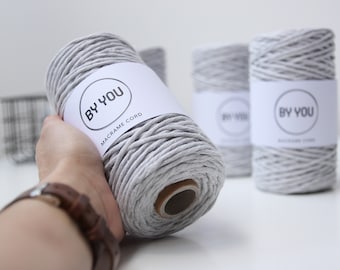 Könnte beinhalten: Eine Rolle graue Makramee-Schnur mit einem weißen Etikett, auf dem "By You Macrame Cord" steht.