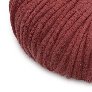 May include: Close-up of a deep red, thick cotton cord. The cord is tightly wound and has a soft, textured surface.