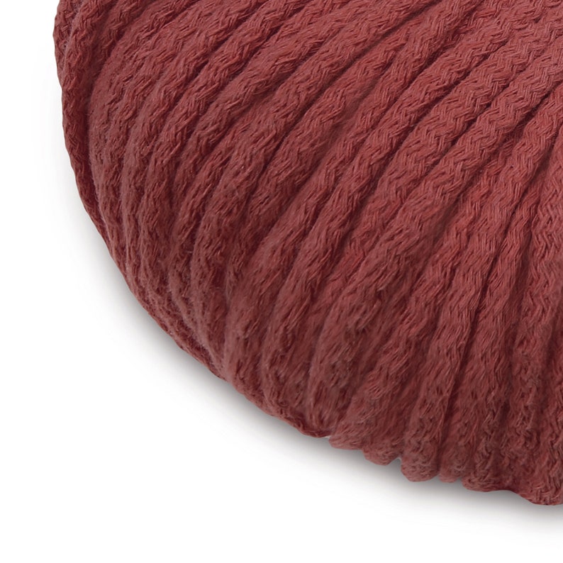May include: Close-up of a deep red, thick cotton cord. The cord is tightly wound and has a soft, textured surface.
