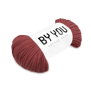 May include: A roll of red cotton cord with a white label that says "BY YOU COTTON CORD".