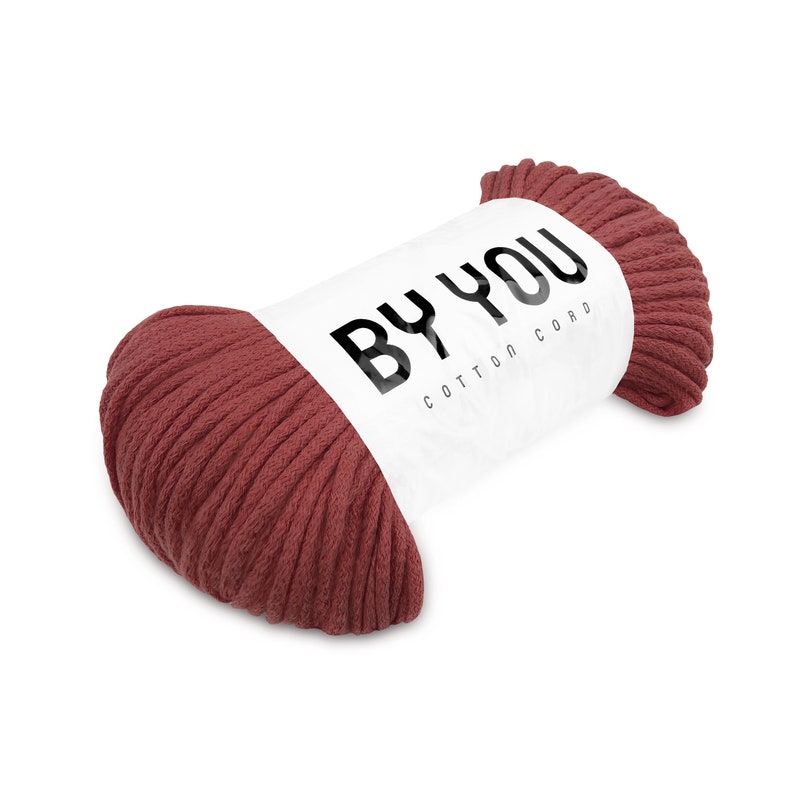 May include: A roll of red cotton cord with a white label that says "BY YOU COTTON CORD".