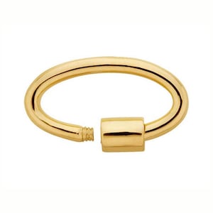 May include: A gold-colored oval-shaped clasp with a screw-in closure. The clasp is made of a shiny, metallic material and is designed to secure a bracelet or necklace. The design is simple and elegant.