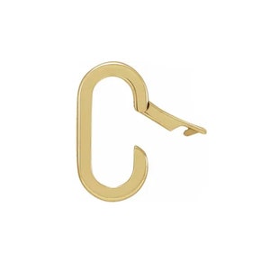 May include: A gold-colored, oval-shaped clasp with a hinged opening. The clasp is designed with a curved, elongated body and a hinged section that opens to secure items. The metal has a polished finish, reflecting light.