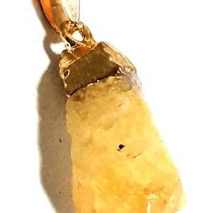 K&ouml;nnte beinhalten: Eine goldene Kettenkette mit einem rohen, gelben Citrin-Kristall-Anh&auml;nger.