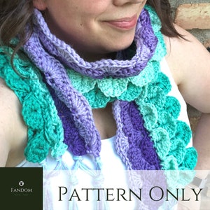 May include: A hand-crocheted scarf in teal, purple, and lavender. The scarf has a scalloped edge and knotted tassels. The text "PATTERN ONLY" is visible. The scarf is a unique accessory.