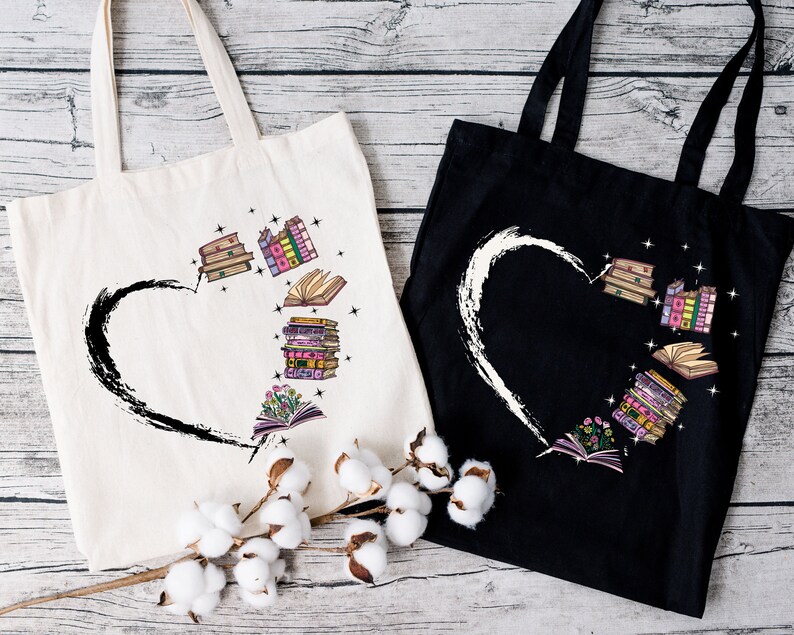 May include: Two tote bags, one cream and one black, with a heart design. The heart is formed by a black brushstroke on the cream bag and a white brushstroke on the black bag. Inside the heart are illustrations of books in various colors.
