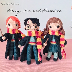 Puede incluir: Patrón de crochet para Harry, Ron y Hermione. El patrón está en inglés. La imagen muestra tres figuras de crochet de Harry Potter, Ron Weasley y Hermione Granger. Cada figura lleva su uniforme de Hogwarts y sostiene una varita.