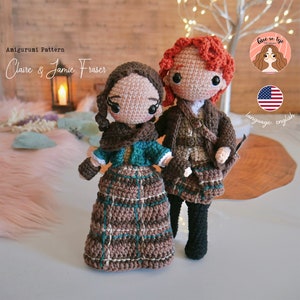 Puede incluir: Muñecas amigurumi de crochet de Claire y Jamie Fraser de la serie Outlander. Las muñecas están vestidas con atuendos escoceses tradicionales con patrones de cuadros. Las muñecas están de pie sobre una superficie de madera.