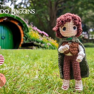 May include: Crochet pattern for Frodo Baggins from The Lord of the Rings. The pattern is in English. The image shows a crocheted doll of Frodo Baggins standing in front of a green door. The doll is wearing a brown vest, brown pants, and a green cloak. The doll is holding a ring in its hand.