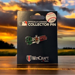 May include: Officially Licensed Collector Pin featuring the Los Angeles Dodgers logo with a Mexican flag design. The pin is on a black card with the words "WinCraft by Fanatics" printed on it.