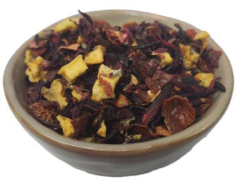 May include: A bowl of loose leaf tea blend with dried fruit and flower petals. The tea blend is a mix of red, orange, and yellow pieces.