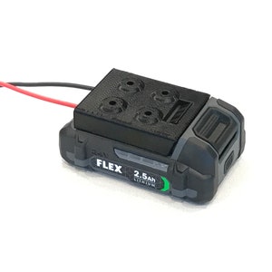 Puede incluir: Una batería de herramienta eléctrica negra y gris con una cubierta de plástico negro y una etiqueta que dice "FLEX 2.5Ah LITHIUM".