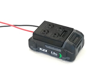 Peut inclure: Une batterie d'outil électrique noire et grise avec un couvercle en plastique noir et une étiquette indiquant "FLEX 2.5Ah LITHIUM".