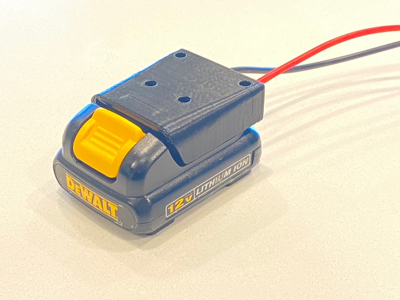 Peut inclure: Une batterie DeWalt 12V lithium-ion noire et jaune avec un bouton de d&eacute;verrouillage jaune.