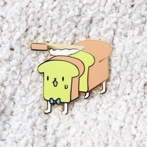 May include: A yellow and orange cartoon bread with a bow tie and legs, being cut with a knife. The bread is smiling and has a small 'u' on its face.