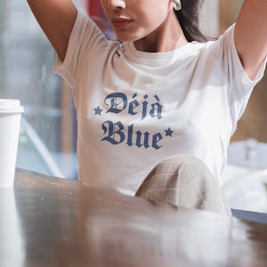 Camiseta azul para bebé DeJa, top corto azul DèJà, inspirado en el merchandising