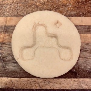 Op de afbeelding: Een witte koek met een reliëfdesign van een raket met een ster erop.