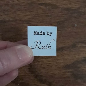 May include: A light blue square label with the text "Made by Ruth" in black lettering.