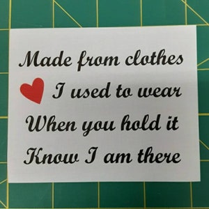 May include: A white card with black text that reads "Made from clothes I used to wear When you hold it Know I am there". A red heart is to the left of the second line of text.