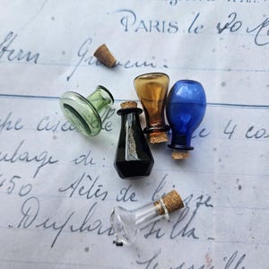 May include: A collection of small, colorful glass bottles with cork stoppers. The bottles are in various shapes and colors, including green, amber, black, and blue. The background is a vintage paper with handwritten script.