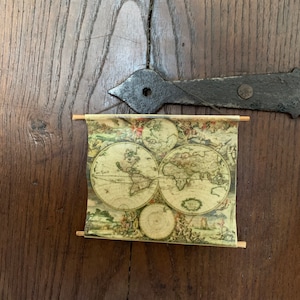 Casa delle bambole con poster scolastico in stile antico con mappa del mondo in miniatura - viaggiatore