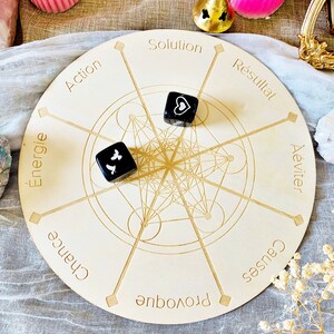 May include: A wooden circular game board with a geometric design and eight sections labeled with French words: "Action", "Energie", "Chance", "Provoque", "Causes", "&Eacute;viter", "R&eacute;sultat", and "Solution". Two black dice with white symbols are on the board.