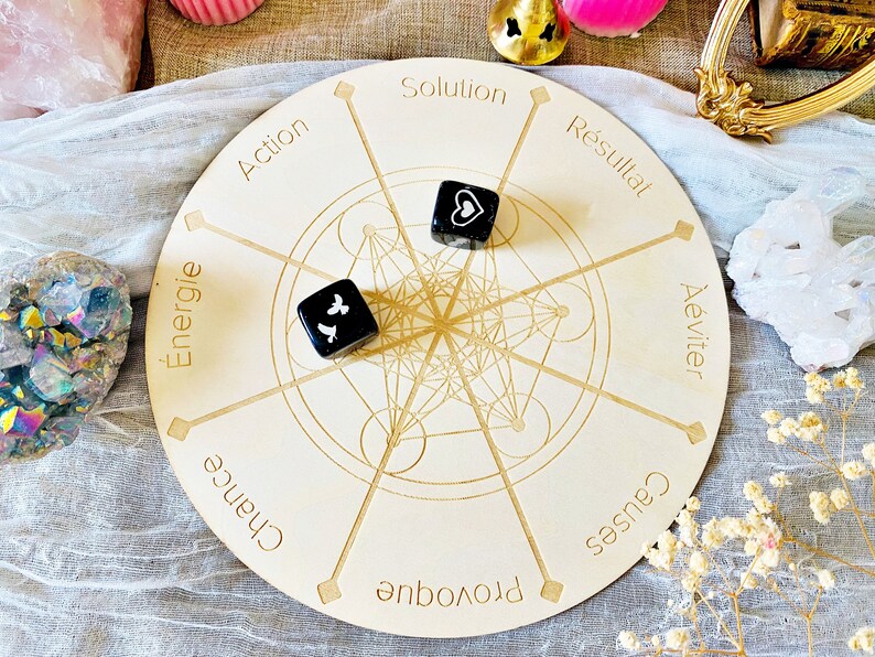 May include: A wooden circular game board with a geometric design and eight sections labeled with French words: "Action", "Energie", "Chance", "Provoque", "Causes", "&Eacute;viter", "R&eacute;sultat", and "Solution". Two black dice with white symbols are on the board.