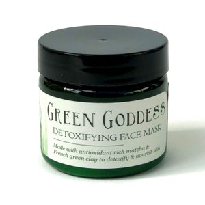 Pu&ograve; includere: Un barattolo verde con un coperchio nero etichettato "GREEN GODDESS DETOXIFYING FACE MASK" con il testo "Made with antioxidant rich matcha & French green clay to detoxify & nourish skin."