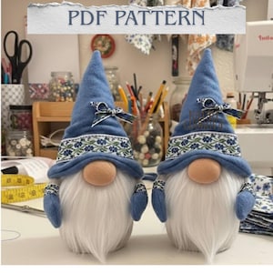 May include: Two handmade gnome figures with blue hats, white beards, and tan noses. The hats have a floral patterned band and a small bow. The text "PDF PATTERN" is at the top of the image.