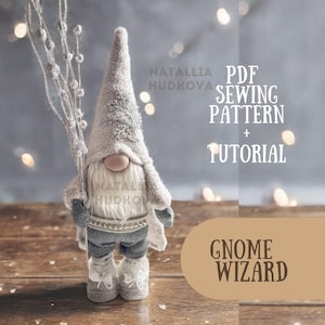Puede incluir: Un gnomo gris y blanco con un sombrero largo blanco y un atuendo de mezclilla azul. El gnomo sostiene una rama con bayas blancas. El texto "PDF SEWING PATTERN + TUTORIAL" está por encima del gnomo, y el texto "GNOME WIZARD" está por debajo del gnomo.