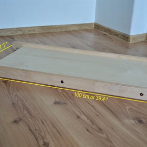 Op de afbeelding: Een houten helling voor kinderen om op te spelen. Het is 100 cm lang en 45 cm breed.