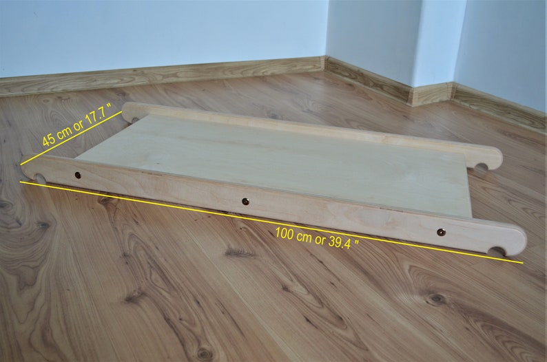 Op de afbeelding: Een houten helling voor kinderen om op te spelen. Het is 100 cm lang en 45 cm breed.