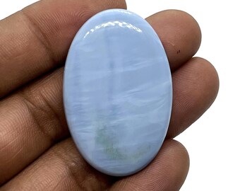 May include: Oval shaped blue opal cabochon gemstone with a white and blue pattern. The stone is smooth and polished.