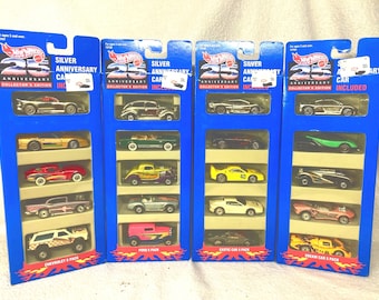 May include: Four Hot Wheels 25th Anniversary Collector's Edition 5-pack sets in blue cardboard packaging. Each set contains five die-cast toy cars, including various models in silver, gold, red, green, yellow, white, and pink color schemes.
