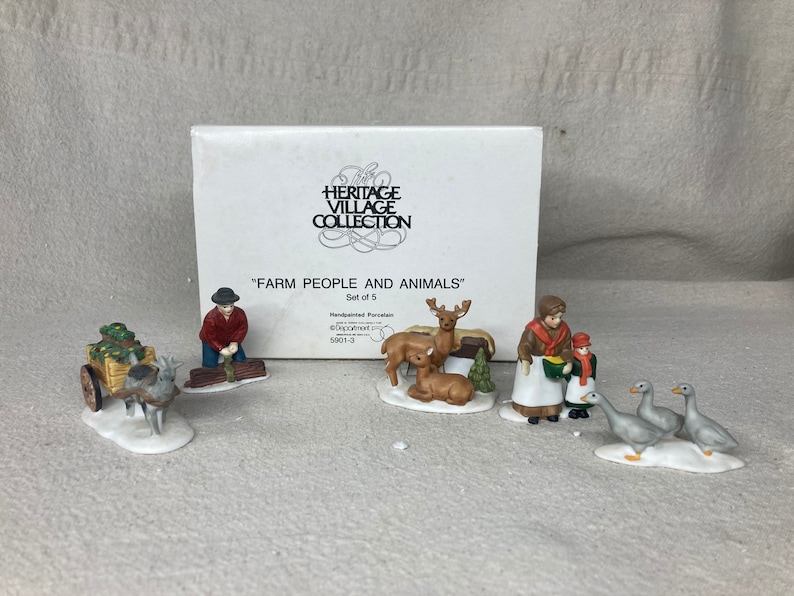May include: A set of six hand-painted porcelain figurines depicting farm people and animals. The set includes a farmer with a cart full of hay, a woman with a child, a deer, a fawn, and two geese. The figurines are part of the Heritage Village Collection.